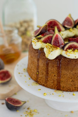 Cream covered sponge cake with figs and pistachios