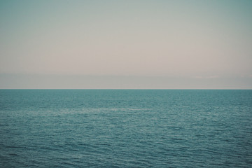Seascape with sea horizon and clear blue sky - background. Sunset at sea. The concept of summer rest in the evening.