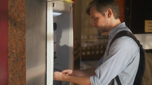 Man using his credit card in an atm for cash withdrawal, pin code money shopping mall or city street europe. Man using his credit card in an atm for cash