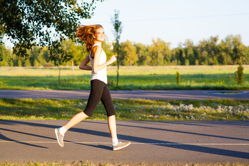 Pretty girl sits on bench in summer park