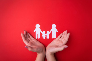 Female tender hands with a family symbol cut out of white paper. Protecting the rights of people and sexual minorities. Love for the children of the world on earth, a clean ecology. View from above.