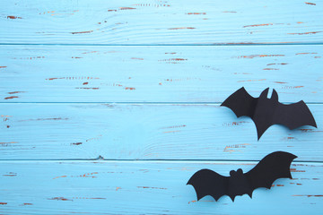 Two halloween paper bats on blue wooden background. Halloween concept