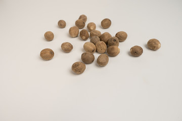 Loose nutmeg on a white plate and plate