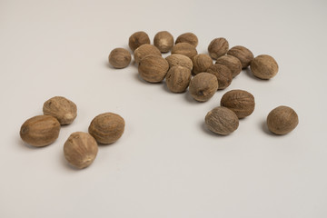 Loose nutmeg on a white plate and plate