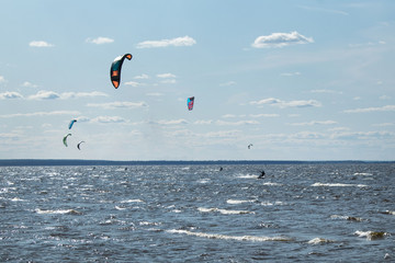 Kite boarding - athletes competition at sea on a summer day