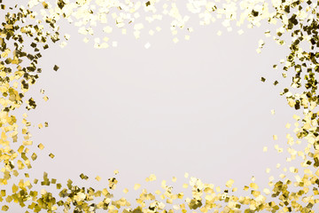 Golden confetti sparkling on white background with copy space