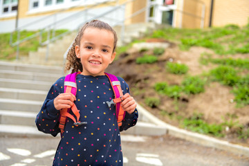 A nice Portrait of cute hispanic girl with backpack at school