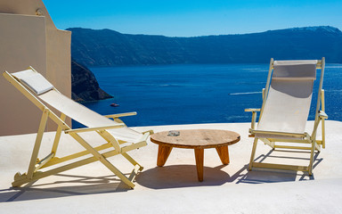 Beautiful view of white typical village and Aegean Sea i. View of blue domed churches -famous tourist attraction in Greece.