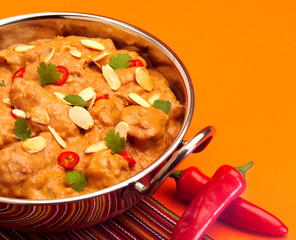 Creamy Chicken Korma with almond flakes in a metal pot