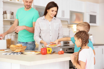 Happy family having breakfast with toasts in kitchen