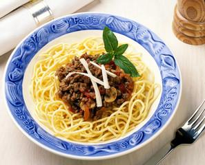Spaghetti Bolognese in blue bowl in table setting
