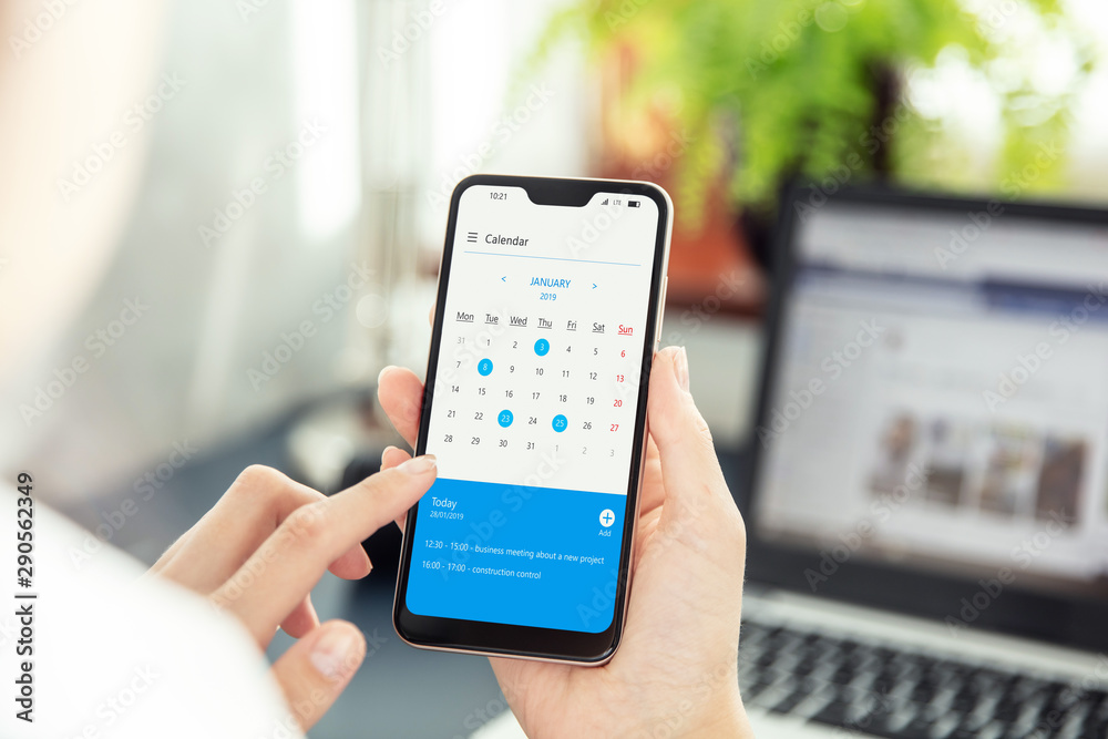 Wall mural businesswoman points smartphone screen and checks calendar on application. application on screen cre