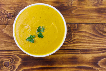 Pumpkin soup on a wooden table. Top view