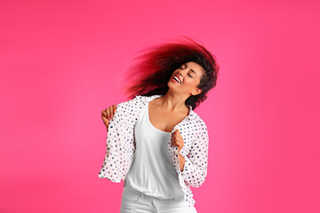 Beautiful Hispanic woman dancing on pink background