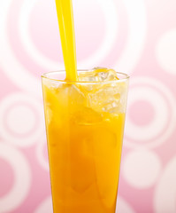 Orange Juice Pour into glass with ice against a funky background
