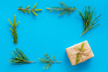 New Year frame with fir branches and present box mockup on blue background top view copy space