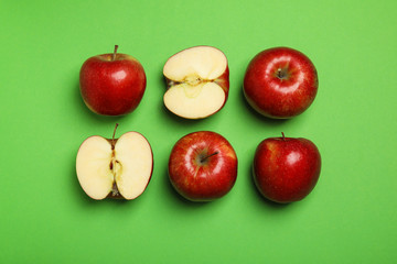Flat lay composition with ripe juicy red apples on green background