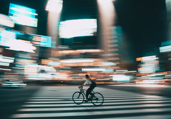 A person riding a bike with the background blurred.