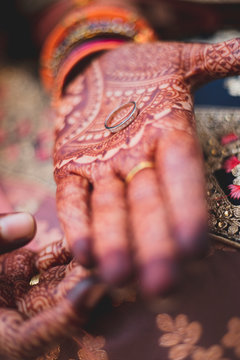 A persons tatooed open hand holding a wedding band.