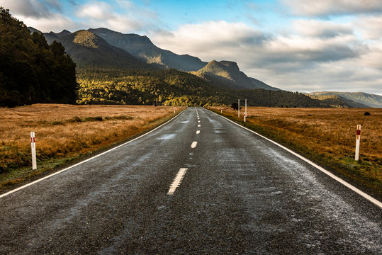 An empty straight two lane road.