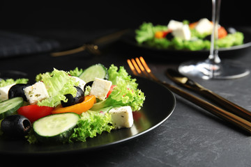 Tasty fresh Greek salad served on dark table