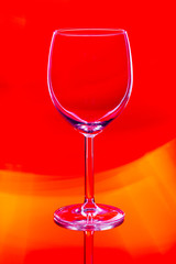 empty wine glass on red light background
