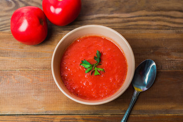 Fresh tomato soup with greens in a bowl