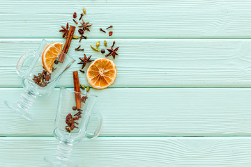 New Year beverage. Ingredients for mulled wine in glasses on green wooden background top view copy...