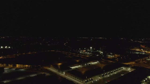 Docks at dark night. Drone flying over warehouse and containers on the harbor. Cargo and shipping industry.