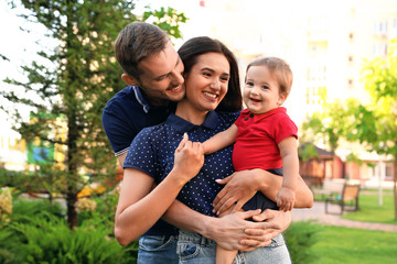 Happy family with adorable little baby outdoors