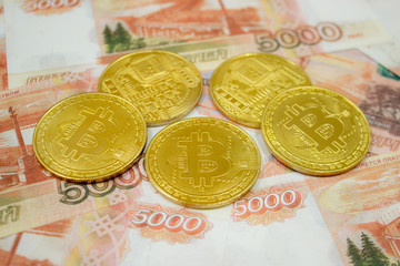 Close-up of Bitcoin coins on 5000 Russian rubles banknote. Crypto currency BTC.