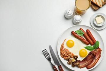 Traditional English breakfast with fried eggs on light table, flat lay. Space for text