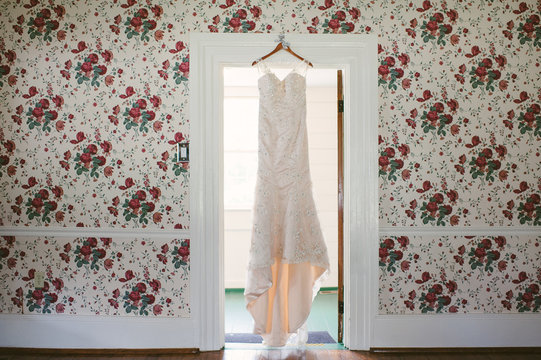white gown hangs from doorway