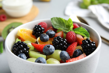 Fresh tasty fruit salad on grey table, closeup