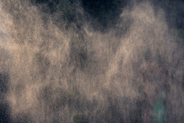 fog from a water fountain against the light of the sun