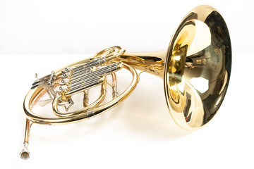 Corno, instrumento musical dorado sobre fondo blanco