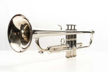 Obraz na płótnie Canvas Trompeta, instrumentos musicales plateados sobre fondo blanco