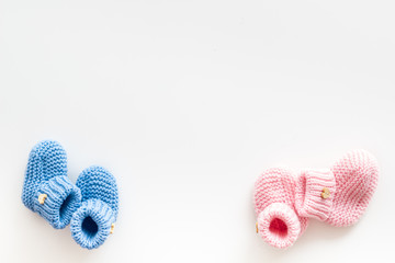 Cute baby booties for girl and boy on white background top view copyspace