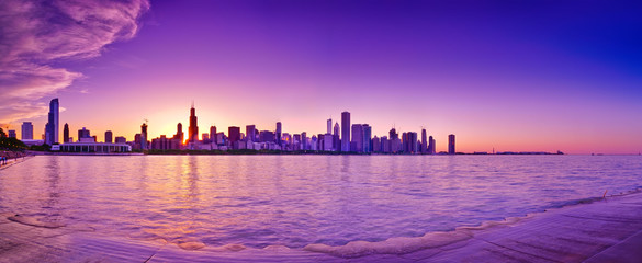 View of Chicago skyline from the shore of Lake Michigan at dusk.