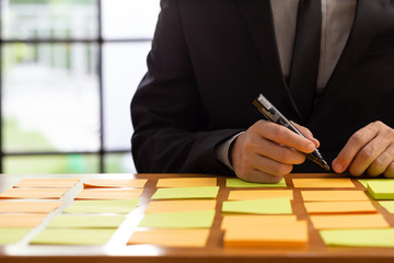 Businessman planning task work with sticky note on table in the office, Scrum board and agile...