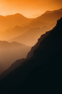 Mountain peaks through an orange haze.