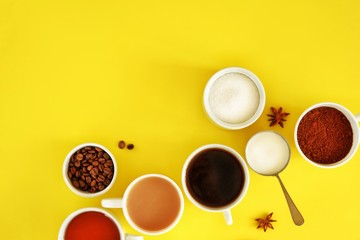 Obraz na płótnie Canvas Flat lay composition of various cups of coffee, tea with sugar, cream and star anise on a bright yellow background. Coffee break. Top view.
