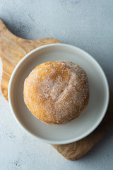 Delicious sugar donuts on a white plate, rustic style.