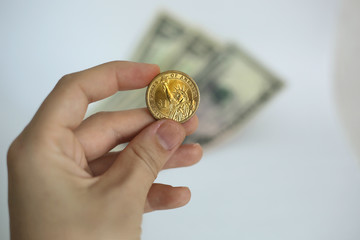 Hand holding US Dollar coin on white background in New York in the USA.