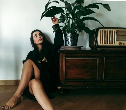 Woman sitting on floor by commode