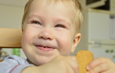 baby with cookies in hands smiles joyfully