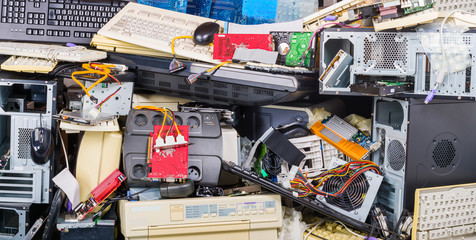 E-waste heap from used computer parts. Refuse separation and recycling. Obsolete or discarded PC hardware components such as printers, chassis, keyboards and mice. Environmental contamination problem.