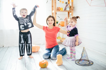 Fototapeta premium Happy family of mother and children prepare for Halloween in decorate the home