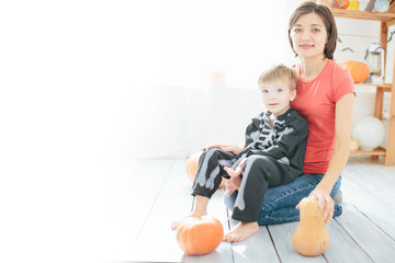 Happy family of mother and children prepare for Halloween in decorate the home