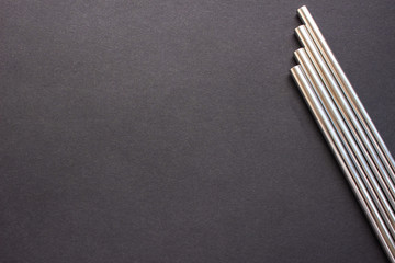 Metal straws on black background. Zero waste. Flat lay 